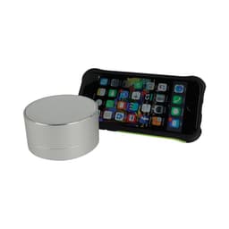 A silver Bluetooth speaker next to a smartphone with a protective case, displaying various app icons.