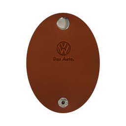 A brown oval-shaped key holder with a metallic button and an embossed logo, featuring the name "Das Auto."