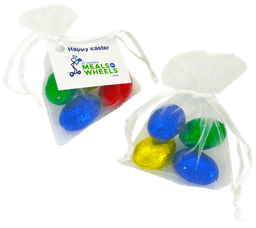 Organza bags containing four mini solid Easter eggs in blue, green, and gold. Each bag is tied with a white ribbon.
