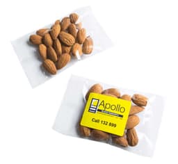 Two clear packets of almonds with a yellow label featuring a logo and contact information.
