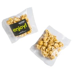 A bag of caramel popcorn featuring golden kernels in a clear wrapper with a logo.