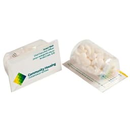 A clear container filled with white mints, placed on a paper card. The card has a logo and branding.