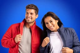 A red puffer jacket and a navy puffer jacket worn by a smiling man and woman against a blue background, both with logos.