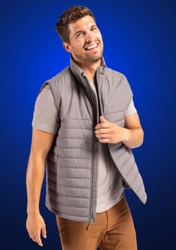 A grey puffer vest with a zip front and a simple design, modelled by a smiling man against a blue background.