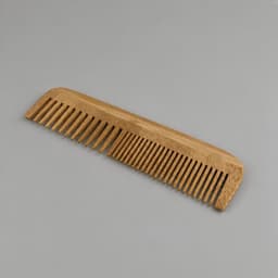 A bamboo comb in a natural wood colour with wide and narrow teeth, featuring a smooth finish.