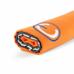 An orange beach towel rolled up, featuring a grey border and a circular logo.