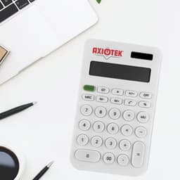 A white calculator with a logo, displaying numbers and various function keys, on a desk with a laptop and stationery.