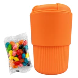 An orange reusable coffee cup with a ribbed design, accompanied by a bag of colourful jelly beans.