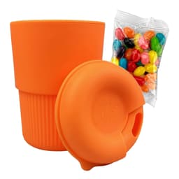 A reusable coffee cup in vibrant orange silicone, accompanied by a bag of colourful jelly beans.