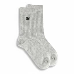 A pair of grey lounge socks featuring a ribbed texture and a logo on one side.