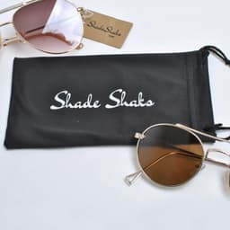 A black microfiber pouch with a logo, accompanied by brown-tinted sunglasses.