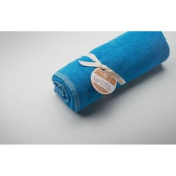 A rolled blue towel secured with a tie and tag, showcasing a soft texture.