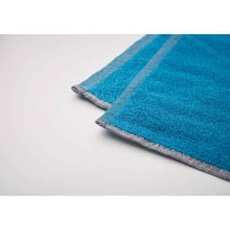 A blue towel with grey stitching, neatly folded at the edges, showcasing its soft, textured fabric.