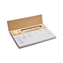 A brown kraft box containing a notepad, sticky notes in pink and yellow, and a wooden ruler.