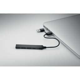 A USB hub connecting multiple devices to a laptop. It is sleek and black in colour, featuring ports for connections.