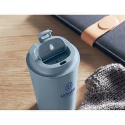 A drink bottle in soft blue with a lid and spout, accompanied by a notebook and knitted fabric.