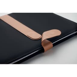 A notebook with a black cover and a tan elastic band closure. It features a smooth, sleek design.