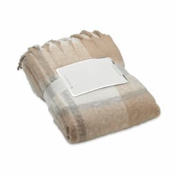 A folded blanket in shades of beige and cream, neatly secured with a plain band.