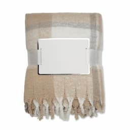 A folded blanket in shades of beige and grey, secured with a silver buckle. The blanket features a checkered pattern and fringe edges.