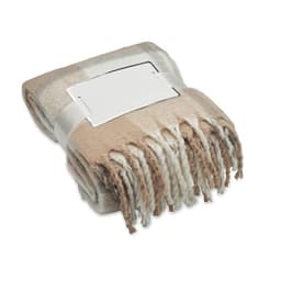 A folded blanket featuring a beige and cream pattern, secured with a ribbon and a blank label.
