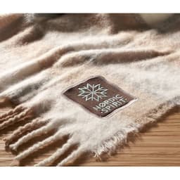 A scarf in soft beige and cream tones with a textured finish and a small branding patch.
