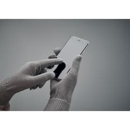 A pair of grey gloves interacting with a smartphone screen, highlighting touchscreen capability.