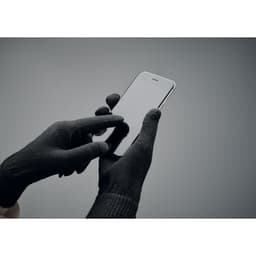 A pair of black gloves interacts with a smartphone against a neutral background. The gloves have a textured finish.