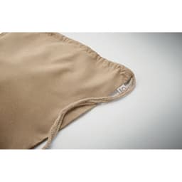A beige drawstring bag with a textured surface and a rope closure, featuring a small label.