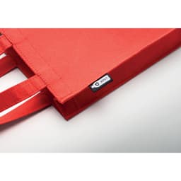 A red felt tote bag with sturdy handles and a small branded label.