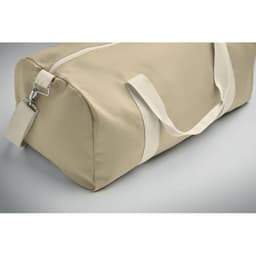 A beige duffle bag with light-coloured handles and a zip closure, featuring a branding logo.