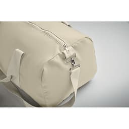 A beige duffle bag with a zipper and adjustable strap, featuring a metal clasp. It has a simple and sleek design.