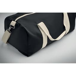 A black duffel bag with contrasting cream straps and a zipper closure, featuring a small tag.