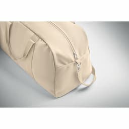 A beige duffle bag with a zip closure and side handle. The bag has a smooth, soft surface.