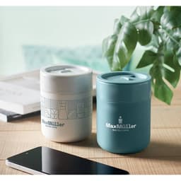 Two drink bottles, one light grey with a patterned design and one teal, placed on a wooden table with a smartphone nearby.