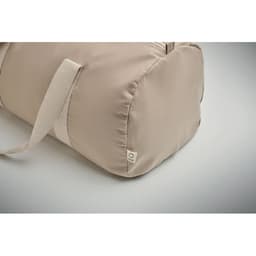 A beige duffel bag with a shoulder strap and a small logo on the side.
