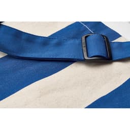 A striped bag featuring blue and cream colours, with a blue adjustable strap and plastic buckle.