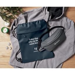 A blue drawstring bag and a grey waist pouch are displayed alongside a grey jacket. Both have branding.