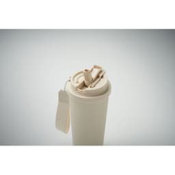 A drink bottle in a cream colour with a flip-top lid and a strap. It features a logo on the side.