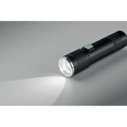 A torch with a sleek black design shines a bright beam of light, featuring a textured grip and a side button.