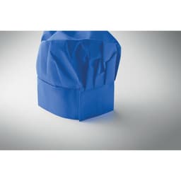 A blue chef's hat with a crumpled texture, standing upright against a light background.