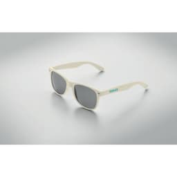 A pair of cream-coloured sunglasses with grey lenses and a logo on the side.