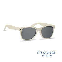 A pair of cream-coloured sunglasses with grey lenses, featuring a logo on the side.