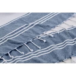 A towel featuring blue and white stripes with decorative tassels along the edges. It has a soft, textured design.