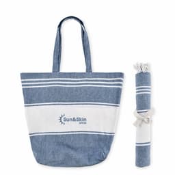 A tote bag in denim blue with white stripes, accompanied by a rolled-up towel, featuring a logo.