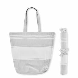 A tote bag in grey and white stripes, accompanied by a rolled-up blanket tied with a ribbon. The bag has long handles.