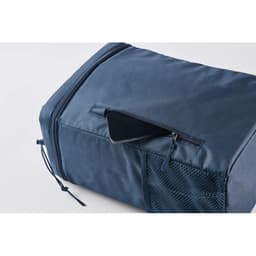 A navy blue travel bag with a zippered pocket and a mesh side pocket, designed for convenience and storage.