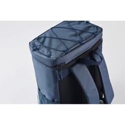 A navy blue backpack cooler with a zippered compartment and bungee cord detail on the top. It has a textured back.