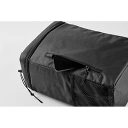 A black travel bag featuring a zippered compartment and a mesh side pocket.