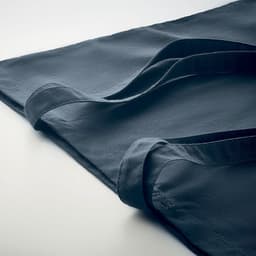 A dark blue tote bag lies flat, featuring long handles and a smooth, textured fabric.