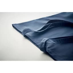 A blue tote bag with long handles, laid flat on a light surface. It has a simple design and no visible branding.
